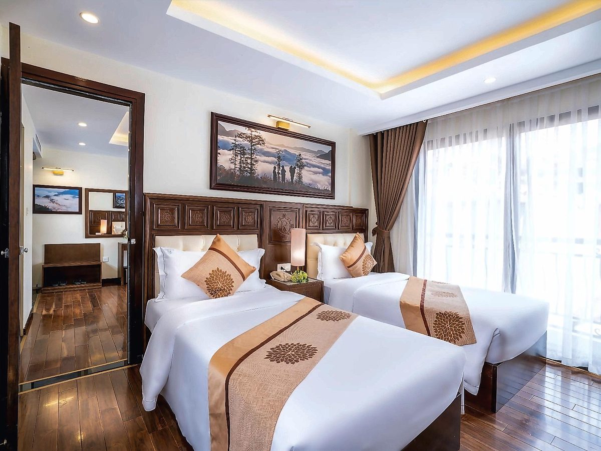 Bedroom with two single beds and an open doorway leading through to a second bedroom