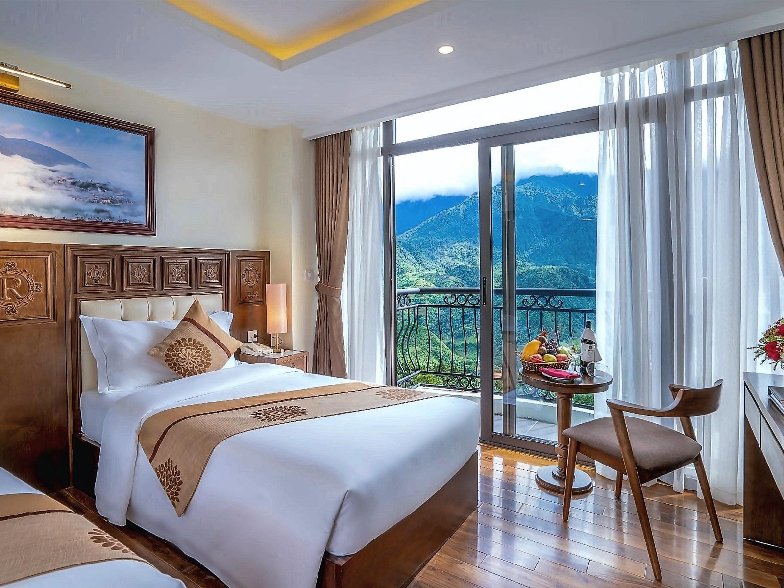 Twin room with carved wooden headboards and a glass balcony door opening onto a green mountain slope